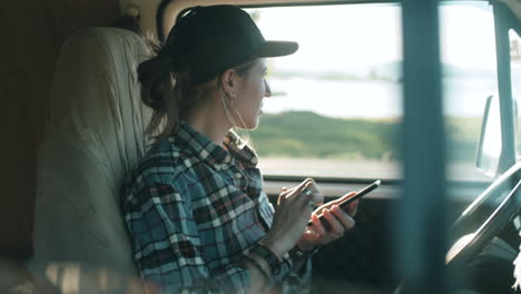 Junge-Frau-Sitzt-Im-Lieferwagen-Und-Benutzt-Smartphone